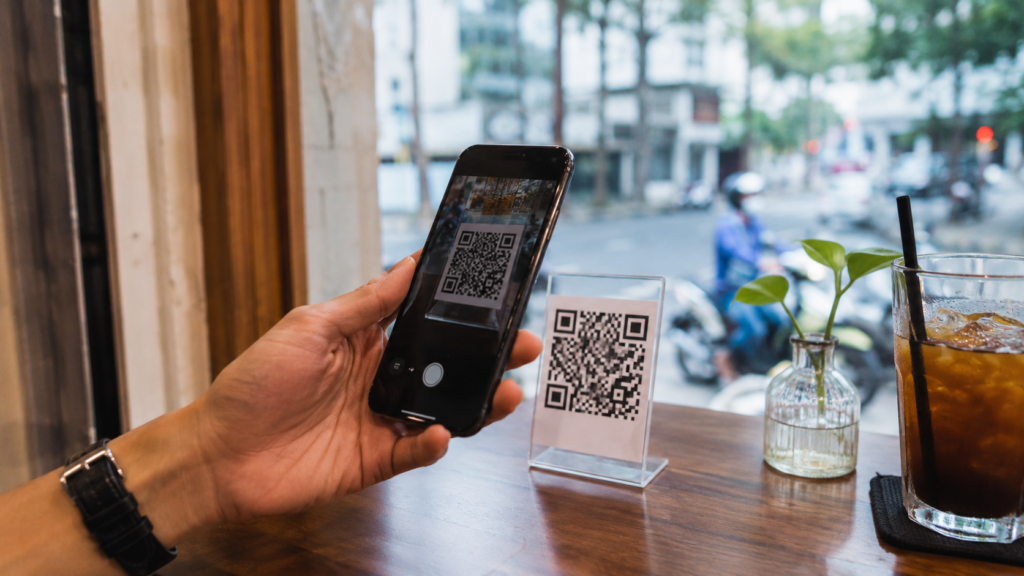 Paiement QR code au Vietnam avec smartphone dans un café urbain.