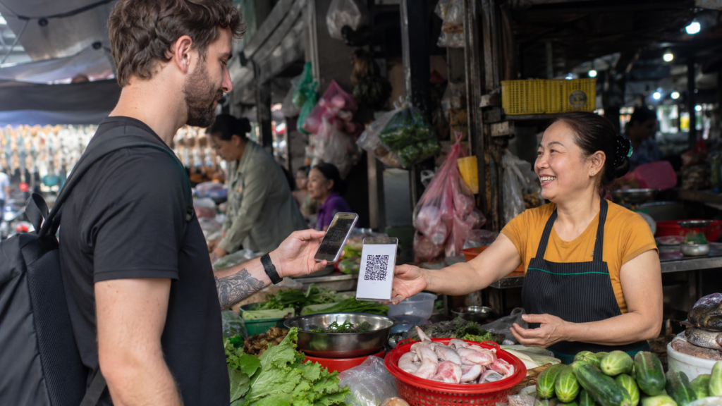 Un client étranger paie par QR code dans un marché vietnamien.